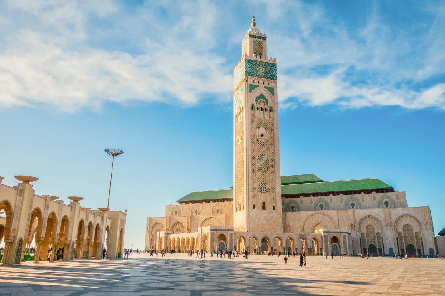 The grand Hassan II Mosque in Casablanca under a blue sky, a popular architectural highlight included in private tours of Morocco.